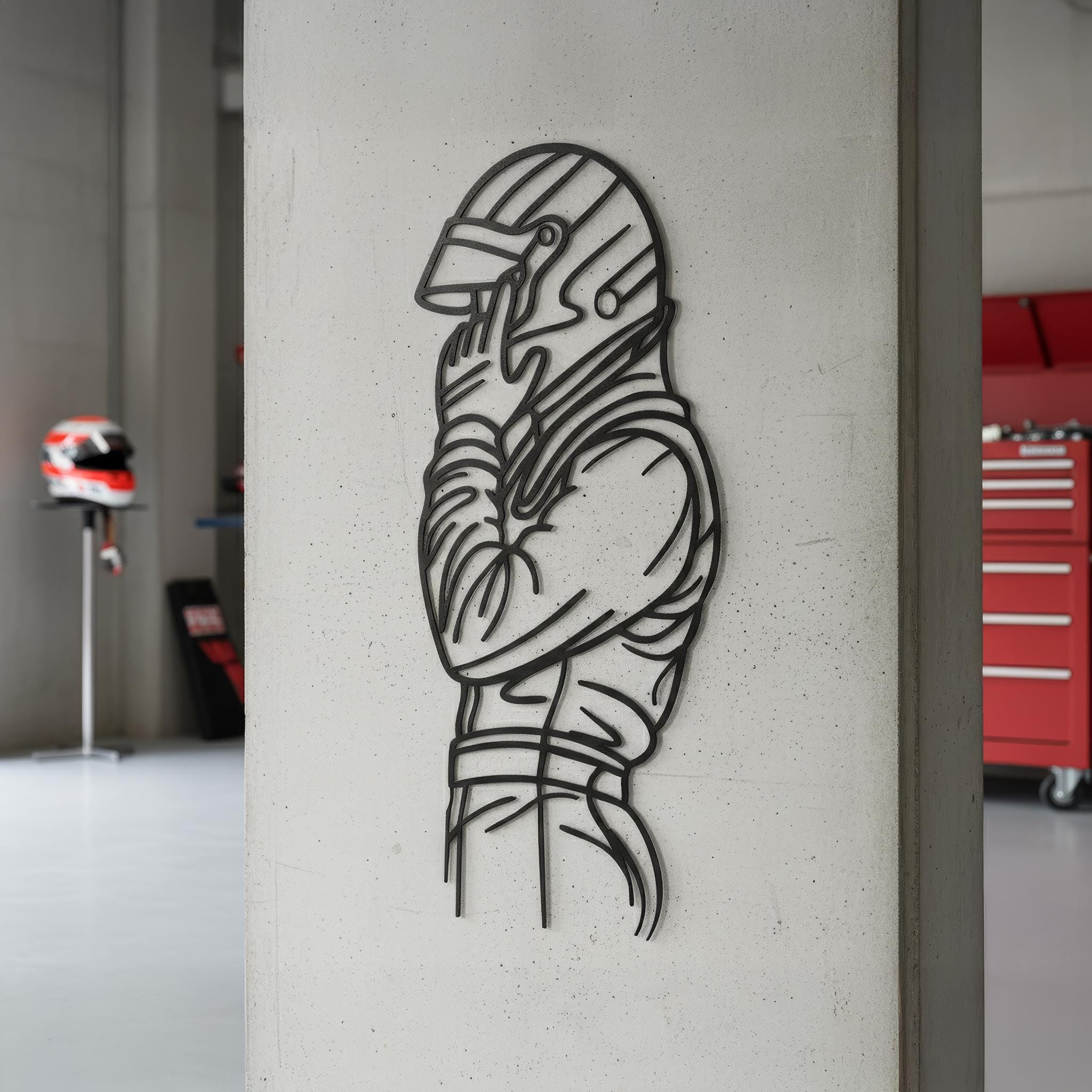 Racing driver silhouette metal wall art on a garage pillar with red toolbox background. CNC laser-cut, matte black powder-coat. Customize sleeve text with name/number. Gift for car lovers; multiple sizes; ready to hang.