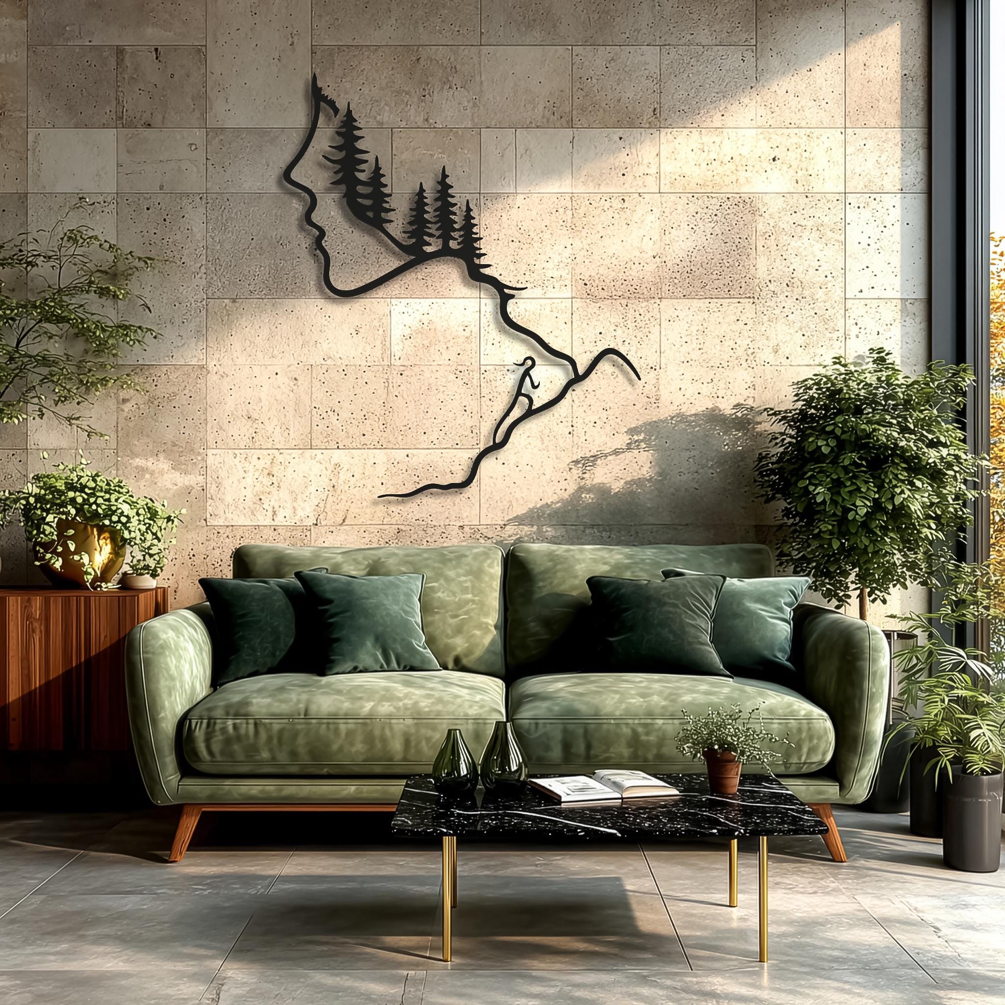 Forest and hiker themed black metal wall sculpture showing a woman’s profile, pine trees and winding mountain path, displayed above a green velvet sofa and plants. Rustic nature metal wall art, cabin and lodge decor, hiking gift, mountain climber line art for living room.