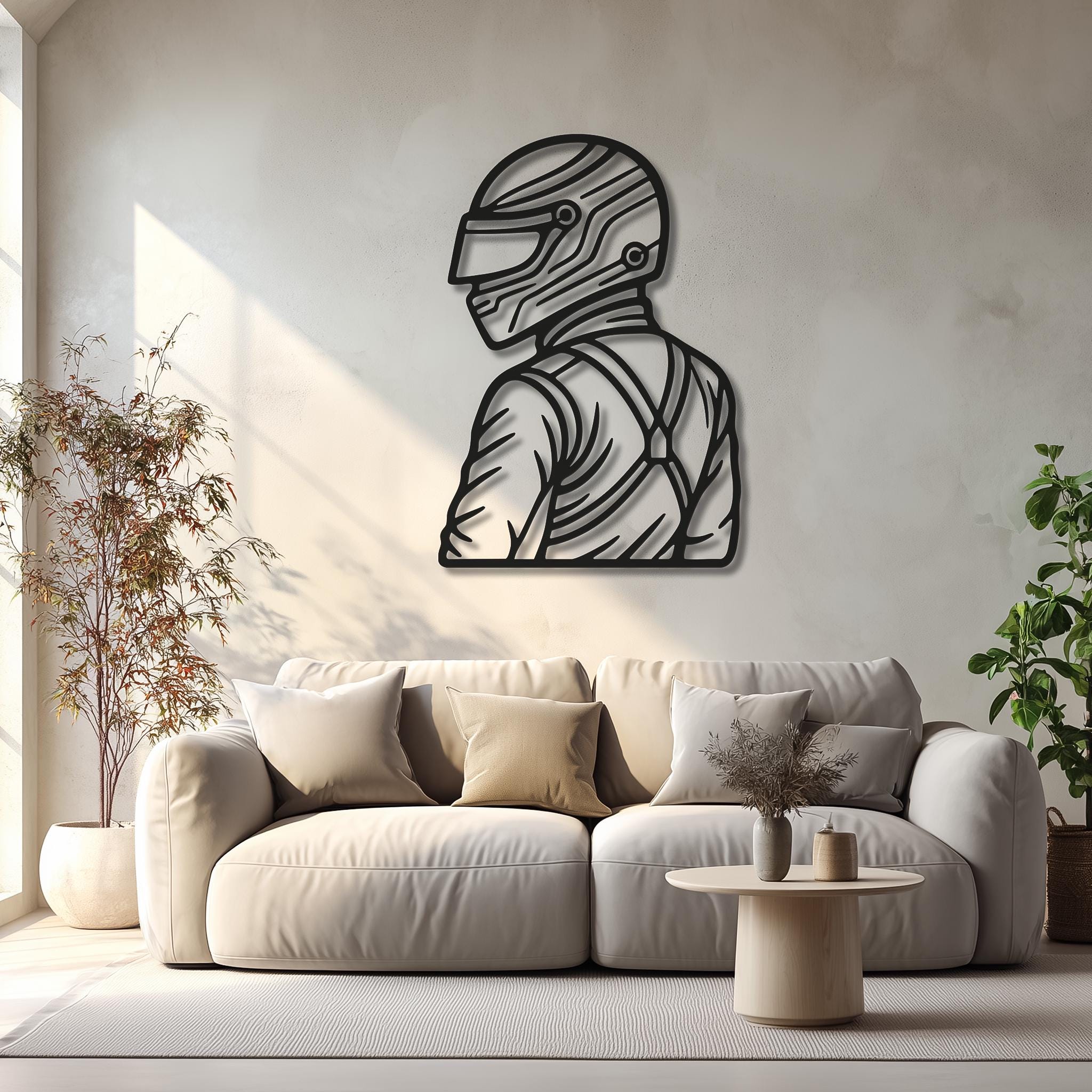 Motorsports driver metal wall art above a beige sofa; matte-black CNC-cut helmet silhouette with harness; natural sunlight and soft shadows; minimalist racing decor for living room; gift for motorsport fans; multiple sizes available; easy to hang, powder-coated finish.