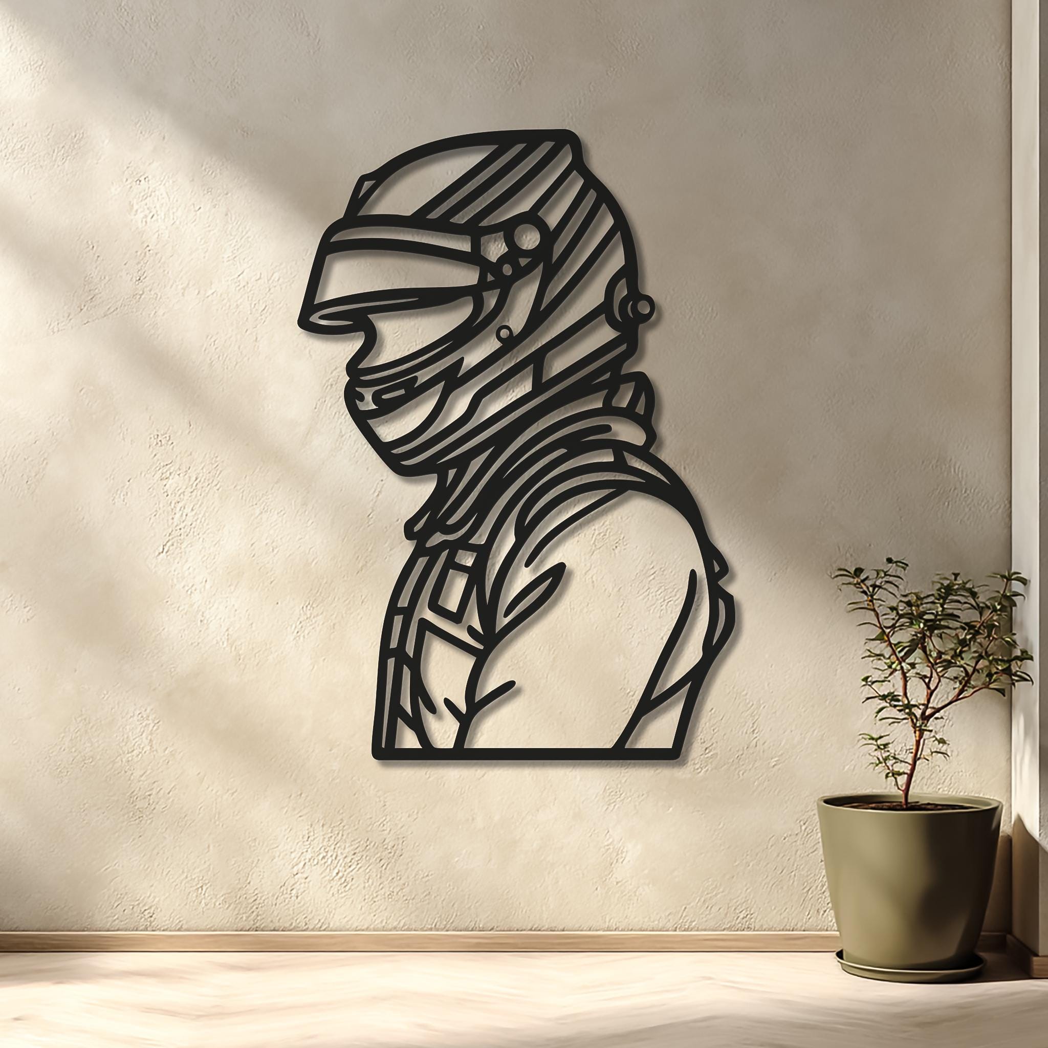 May include: A black metal wall art piece depicting a racing driver in a helmet, featuring the name HAGER in capital letters at the base. The silhouette is mounted on a light-colored wall above a desk setup with two monitors and a gaming chair.