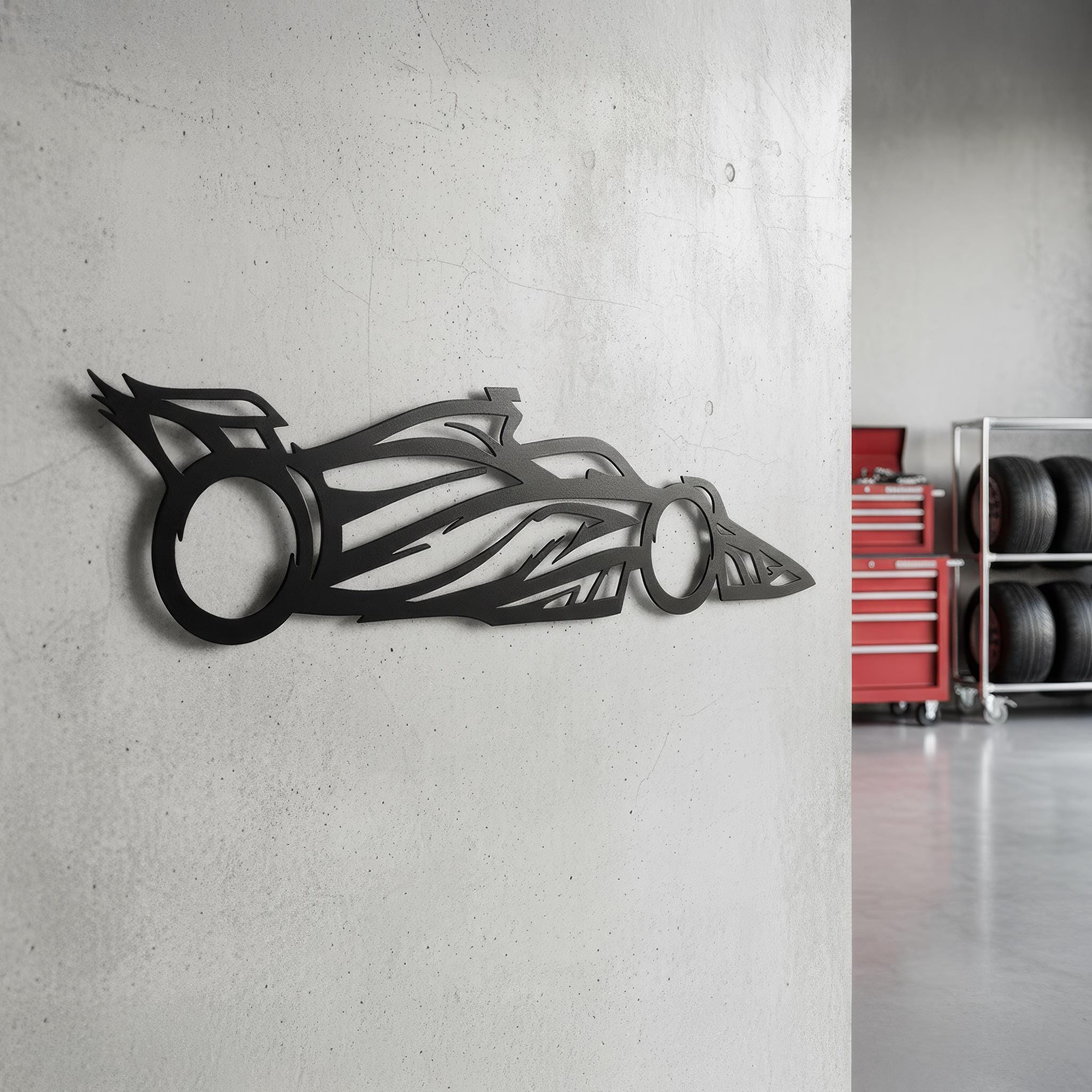 Open-wheel motorsports car silhouette wall art in a garage; matte black CNC laser-cut steel; man cave and workshop décor; rust-resistant, ready to hang; gift for racing enthusiasts.