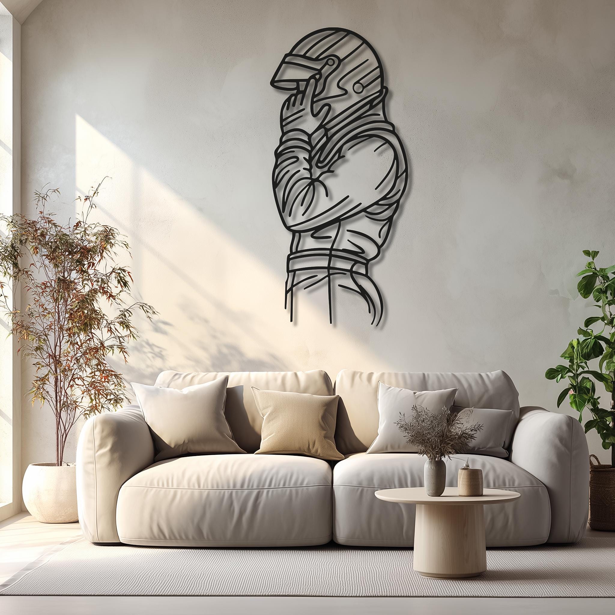 CNC laser-cut motorsports driver silhouette metal wall art in matte black on a bright living-room wall; soft natural light. Personalized sleeve text (name/number/team) available. Modern home, man cave or garage décor; multiple sizes; ready to hang.