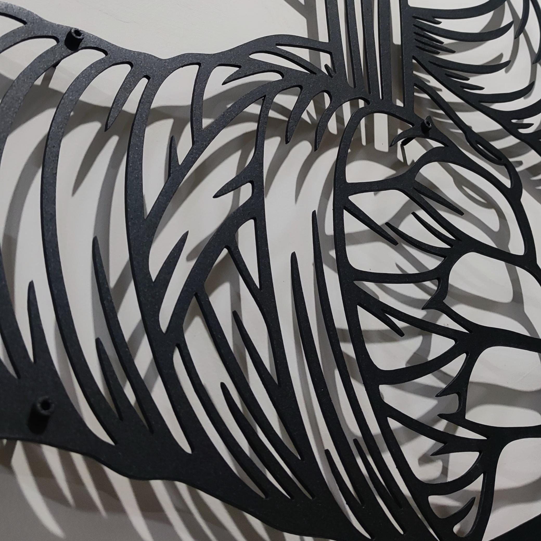 May include: A black metal wall art piece depicting two hands wrapping boxing hand wraps. The design features bold, clean lines and a silhouette style, showing the hands pulling the fabric tight. The artwork is mounted on a light-colored wall.