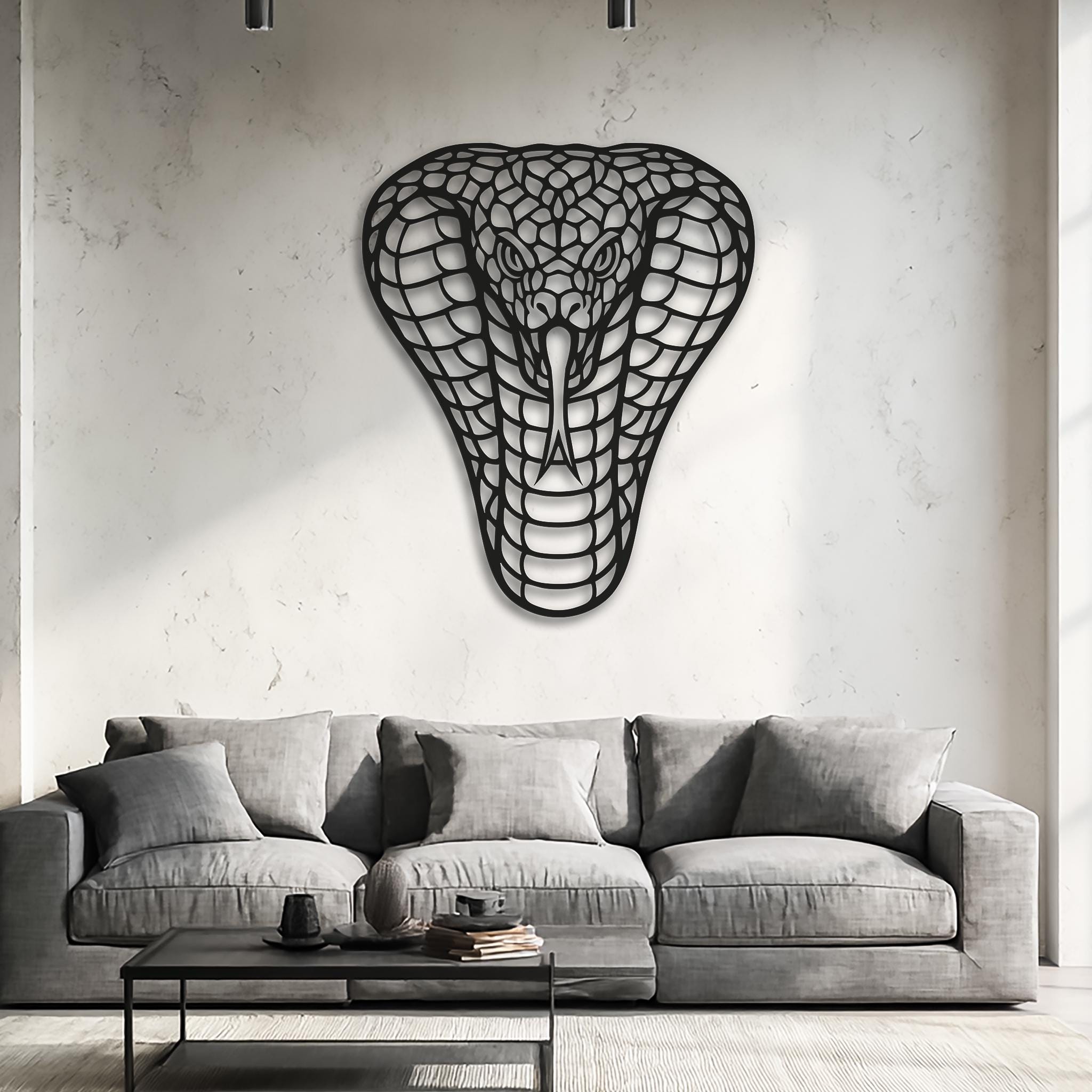 Cobra wall art over a grey sofa; clean modern living room; black laser-cut steel with openwork scales; XL statement wall decor; minimalist neutral palette; fits Scandinavian and industrial interiors