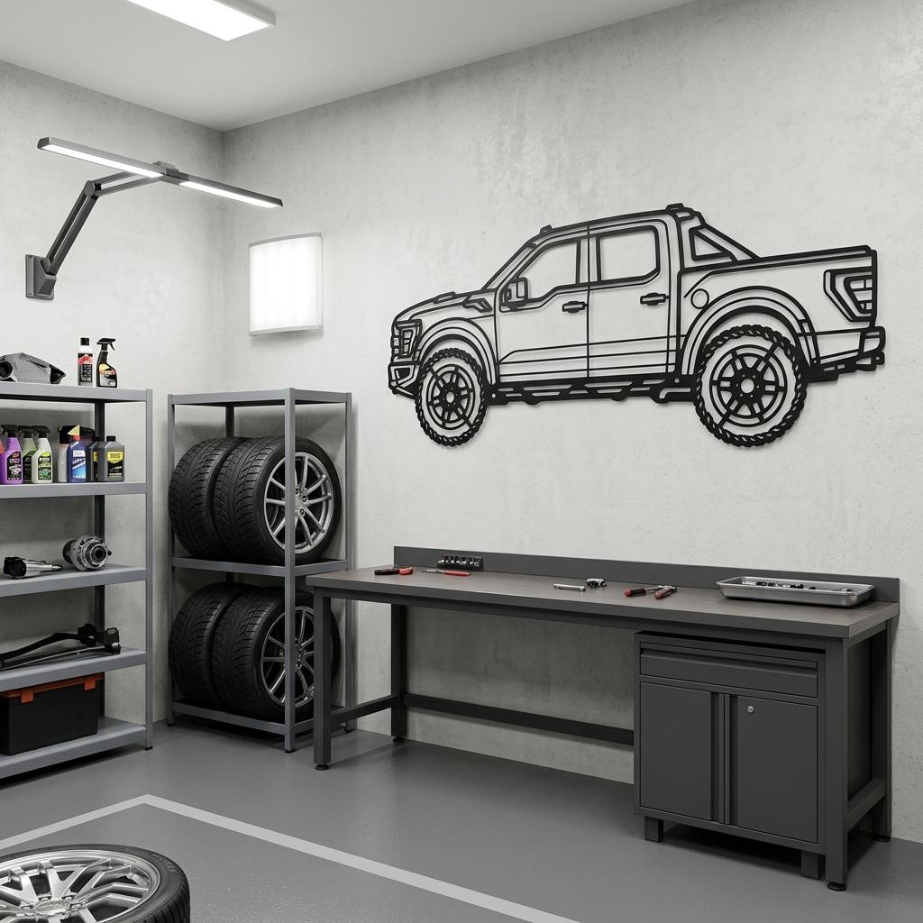 May include: A black metal wall art piece shaped like a pickup truck silhouette, featuring detailed outlines of the body, windows, wheels, and tires. The flat, laser-cut design is mounted on a light gray wall above a dark gray metal workbench.