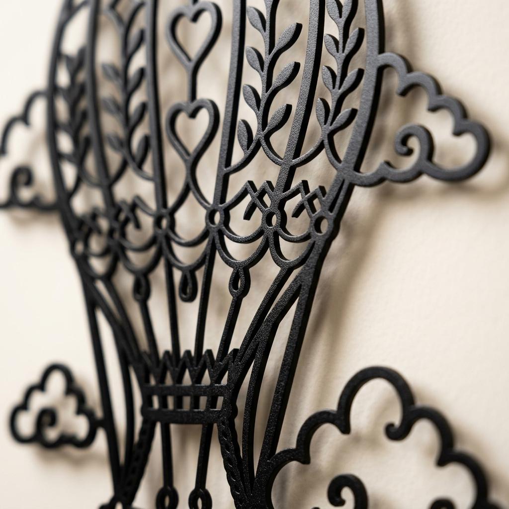Macro detail of the black powder coated hot air balloon nursery sign, showing textured metal finish, crisp laser cut curves, heart and cloud cutouts, and premium custom baby birth stats wall art quality.